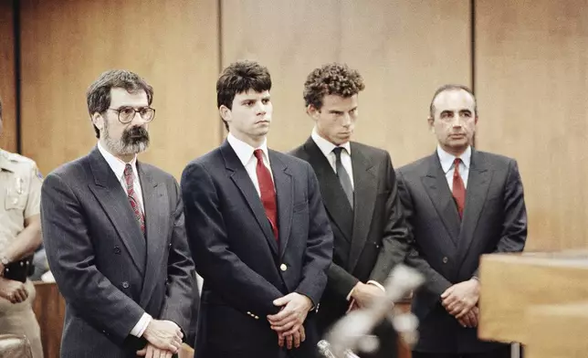 FILE - Lyle Menendez, second from left, and his brother, Erik, second from right, are flanked by their attorneys Gerald Chaleff, left, and Robert Shapiro, as the brothers delayed entering pleas through their attorneys in Beverly Hills Municipal Court, March 13, 1990. (AP Photo/Nick Ut, File)