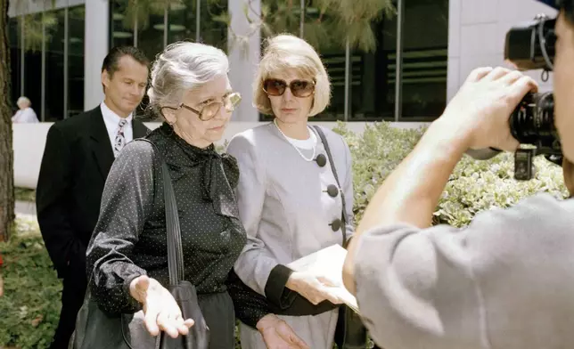 FILE - Maria Menendez, grandmother of two Beverly Hills brothers charged with murdering their millionaire parents, left, encounters news cameras as Jill Lansing, one of the defense attorneys in the case, looks on, outside the Van Nuys courthouse in Los Angeles, June 14, 1993. (AP Photo/Mark J. Terrill., File)