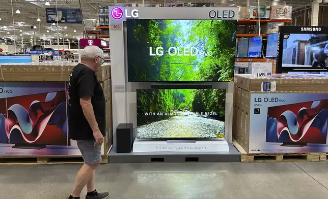 FILE - A shopper examines large-screen televisions on display in a Costco warehouse on Sept. 19, 2024, in Lone Tree, Colo. (AP Photo/David Zalubowski, File)