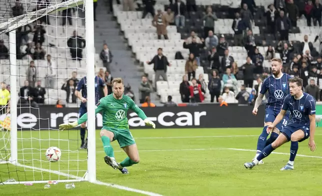 Malmo's goalkeeper Ricardo Friedrich fails to stop a shot by Besiktas' Ernest Muci to open the score during the Europa League opening phase soccer match between Besiktas and Malmo at the Besiktas stadium in Istanbul, Turkey, Wednesday, Nov. 6, 2024. (AP Photo/Khalil Hamra)