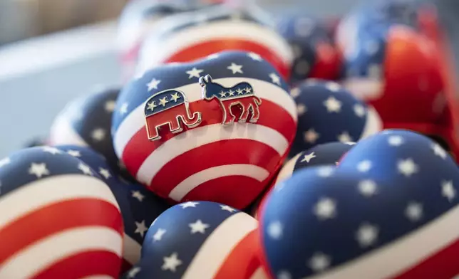 Republican and Democratic Party pins are displayed at a venue as guests watch a television broadcast of U.S. elections in Hong Kong, Wednesday, Nov. 6, 2024. (AP Photo/Chan Long Hei)