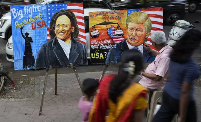 Art teacher Prithviraj Kambli paints posters of US Vice President Kamala Harris and former US President Donald Trump outside his school in Mumbai, India, Tuesday, Nov. 5, 2024. (AP Photo/Rajanish Kakade)