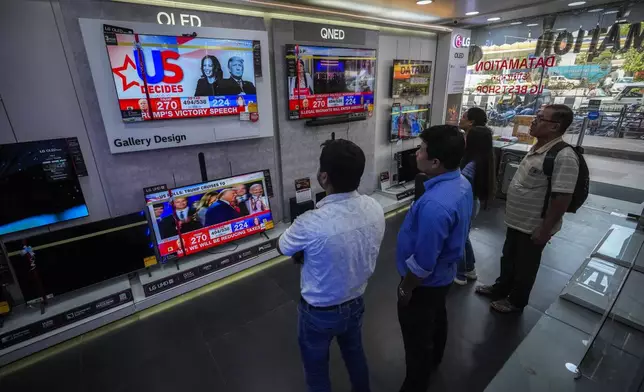 Indian people watch results of U.S. elections on a television in Guwahati, India, Wednesday, Nov. 6, 2024. (AP Photo/Anupam Nath)