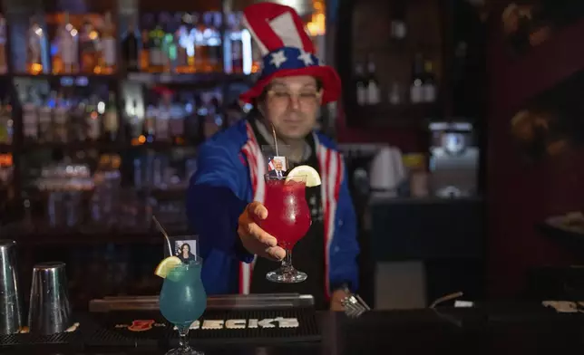 Bartender serves drinks with the pictures of the Republican presidential nominee former President Donald Trump and Democratic presidential nominee Vice President Kamala Harris on U.S. Election Day to customers watching results roll in at a bar in Jerusalem, Wednesday, Nov. 6, 2024. (AP Photo/Ohad Zwigenberg)