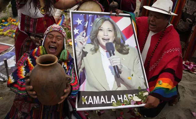 Shamans perform a good luck ritual holding photo a poster of Democratic presidential nominee Vice President Kamala Harris, at the beach in Lima, Peru, Tuesday, Nov. 5, 2024. (AP Photo/Martin Mejia)