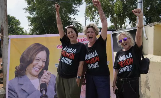 From left, Fiana Jones of United Kingdom, Devony Evans and Sajron Silalenka of United States wearing tees and cheer for Democratic presidential nominee Vice President Kamala Harris outside a temple in Thulasendrapuram, the ancestral village of Harris, in Tamil Nadu state, India, Tuesday, Nov. 5, 2024. (AP Photo/Aijaz Rahi)