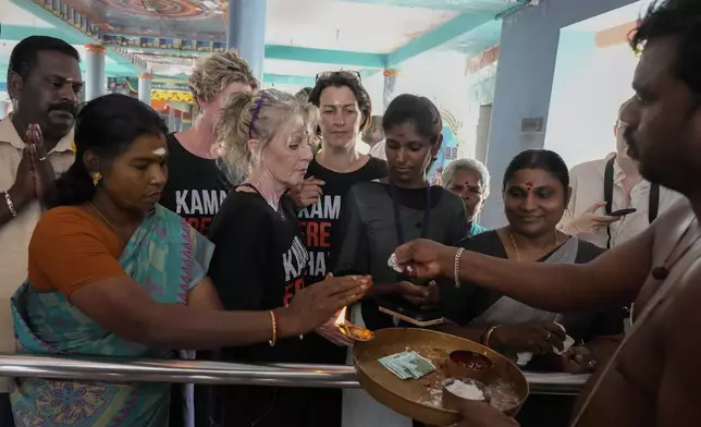 Local villagers and international tourists receive blessings from a priest after participating in special prayers for the victory of Democratic presidential nominee Vice President Kamala Harris, at Sri Dharmasastha Hindu temple in Thulasendrapuram, the ancestral village of Harris, in Tamil Nadu state, India, Tuesday, Nov. 5, 2024. (AP Photo/Aijaz Rahi)