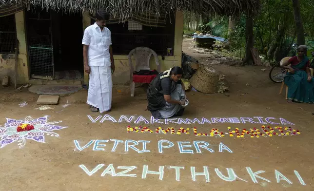 Local politician Arulmozhi Sudhakar prepares a Kolam, a traditional art work using colored powder, that reads "Greeting America, our wishes for Kamala Harris' victory" for Democratic presidential nominee Vice President Kamala Harris, in Thulasendrapuram, the ancestral village of Harris, in Tamil Nadu state, India, Tuesday, Nov. 5, 2024. (AP Photo/Aijaz Rahi)