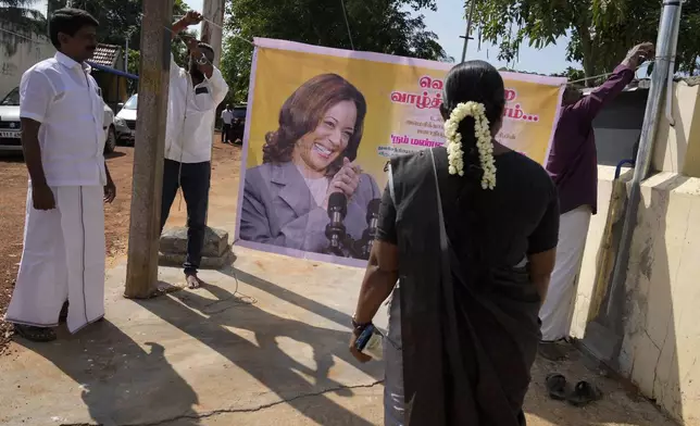 Villagers tie a banner featuring Democratic presidential nominee Vice President Kamala Harris outside a temple in Thulasendrapuram, the ancestral village of Harris, in Tamil Nadu state, India, Tuesday, Nov. 5, 2024. (AP Photo/Aijaz Rahi)