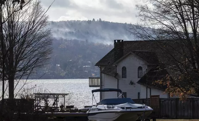 Smoke rises from a wildfire in a forested mountain area across from Greenwood Lake, Monday, Nov. 11, 2024, in Warwick, New York. (AP Photo/Stefan Jeremiah)