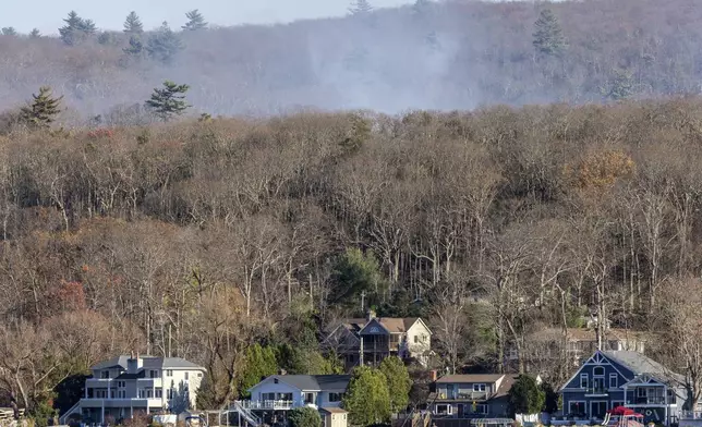 Smoke rises from a wildfire behind a row of lakefront properties in the town of Awosting, as seen from across Greenwood Lake, Lakeside, N.J., Monday, Nov. 11, 2024. (AP Photo/Stefan Jeremiah)