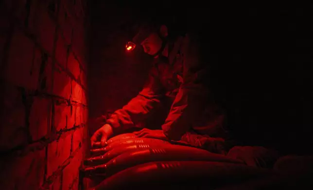 A Ukrainian serviceman of the Bugskiy Gard unit prepares a 120mm mortar before firing towards Russian positions on the front line, in the Kherson region, Ukraine, Sunday, Nov. 3, 2024. (AP Photo/Marko Ivkov)