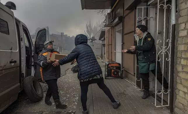 Local women unload food products from a minivan into the last shop operating in Kurakhove, Donetsk region, Ukraine, on Nov. 7, 2024. (AP Photo/Anton Shtuka)