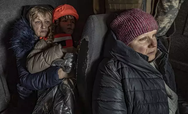 Katia, 11, with her grandmother and mother sit in an armoured minivan during en evacuation by the "White Angels" police unit in Kurakhove, Donetsk region, Ukraine, on Nov. 4, 2024. (AP Photo/Anton Shtuka)