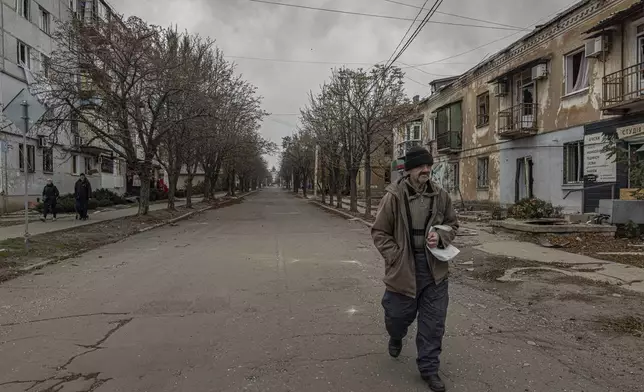 A man walks on a street as he looks for food in Kurakhove, Donetsk region, Ukraine, on Nov. 7, 2024. (AP Photo/Anton Shtuka)