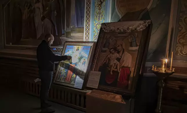 A man prays in front of an icon inside an Orthodox Church in Kurakhove, Donetsk region, Ukraine, on Nov. 7, 2024. (AP Photo/Anton Shtuka)