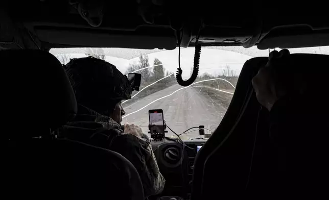 Pipa Vasyl, a policeman of the "White Angels" drives in an armoured minivan during en evacuation in Kurakhove, Donetsk region, Ukraine, on Nov. 4, 2024. (AP Photo/Anton Shtuka)