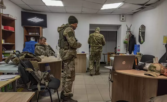 Artem Shchus, colonel of the Kurakhove police unit, left, sits in a basement in Kurakhove, Donetsk region, Ukraine, on Nov. 7, 2024. (AP Photo/Anton Shtuka)