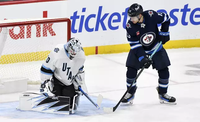 Utah Hockey Club's goaltender Karel Vejmelka (70) makes a save as Winnipeg Jets' Gabriel Vilardi (13) looks for the rebound during the first period of an NHL hockey game in Winnipeg, Manitoba, Tuesday Nov. 5, 2024. (Fred Greenslade/The Canadian Press via AP)