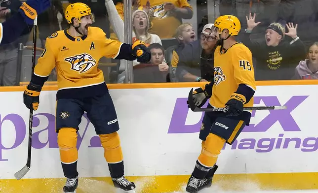 Nashville Predators left wing Filip Forsberg, left, celebrates his second goal of the game with Alexandre Carrier (45) during the second period of an NHL hockey game against the Utah Hockey Club Saturday, Nov. 9, 2024, in Nashville, Tenn. (AP Photo/Mark Humphrey)