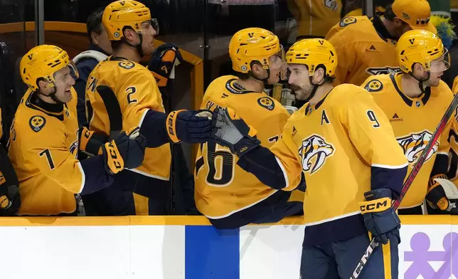 Nashville Predators left wing Filip Forsberg (9) is congratulated after scoring a goal against the Utah Hockey Club during the first period of an NHL hockey game Saturday, Nov. 9, 2024, in Nashville, Tenn. (AP Photo/Mark Humphrey)