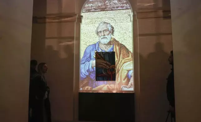 An image of St. Peter is projected on a screen during the preview to the press of the exhibition 'Petros eni', which is part of the project "St. Peter's Basilica: AI-Enhanced Experience" at the Vatican, Saturday, Nov. 9, 2024. (AP Photo/Gregorio Borgia)