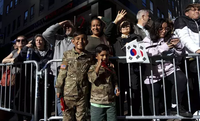 Dereck Rodriguez 10, and his brother, Thiago Rodriguez, 6, wait for their father Mauro Rodriguez, who is in the Army, to march past during the annual Veterans Day Parade, Monday, Nov. 11, 2024, in New York. (AP Photo/Adam Gray)
