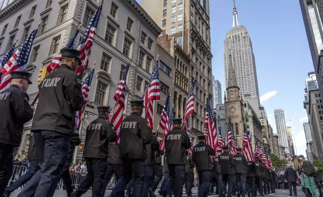 Member of the New York City Fire Department (FDNY) carry American flags during the annual Veterans Day Parade, Monday, Nov. 11, 2024, in New York. (AP Photo/Adam Gray)