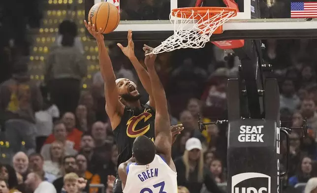 Cleveland Cavaliers forward Evan Mobley (4) shoots as Golden State Warriors forward Draymond Green (23) defends in the first half of an NBA basketball game, Friday, Nov. 8, 2024, in Cleveland. (AP Photo/Sue Ogrocki)