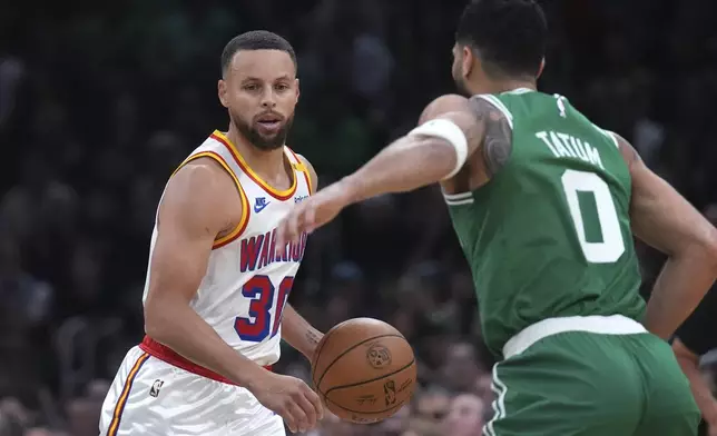 Golden State Warriors guard Stephen Curry (30) sets to drive against Boston Celtics forward Jayson Tatum (0) during the first half of an NBA basketball game, Wednesday, Nov. 6, 2024, in Boston. (AP Photo/Charles Krupa)