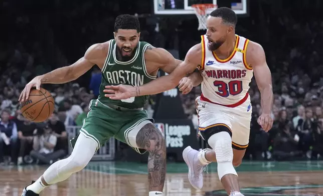 Boston Celtics forward Jayson Tatum, left, drives to the basket against Golden State Warriors guard Stephen Curry during the second half of an NBA basketball game, Wednesday, Nov. 6, 2024, in Boston. (AP Photo/Charles Krupa)