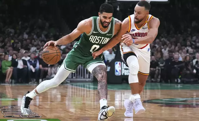 Boston Celtics forward Jayson Tatum, left, drives to the basket against Golden State Warriors guard Stephen Curry during the second half of an NBA basketball game, Wednesday, Nov. 6, 2024, in Boston. (AP Photo/Charles Krupa)