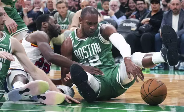 Boston Celtics center Al Horford, right, battles Golden State Warriors forward Andrew Wiggins (22) for a loose ball during the first half of an NBA basketball game, Wednesday, Nov. 6, 2024, in Boston. (AP Photo/Charles Krupa)