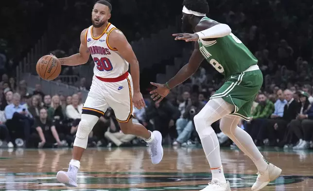 Golden State Warriors guard Stephen Curry (30) drives against Boston Celtics center Neemias Queta (88) during the first half of an NBA basketball game, Wednesday, Nov. 6, 2024, in Boston. (AP Photo/Charles Krupa)