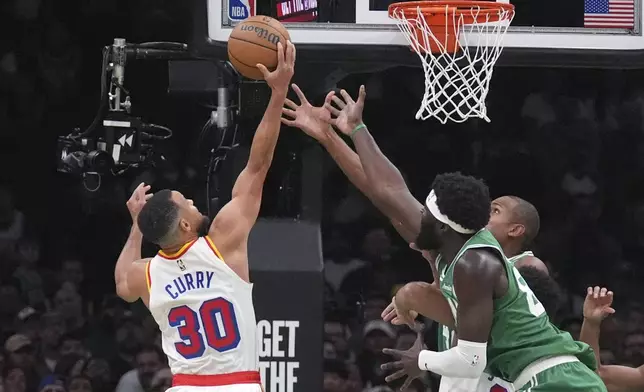 Golden State Warriors guard Stephen Curry (30) grabs a rebound against Boston Celtics center Neemias Queta, right, during the first half of an NBA basketball game, Wednesday, Nov. 6, 2024, in Boston. (AP Photo/Charles Krupa)