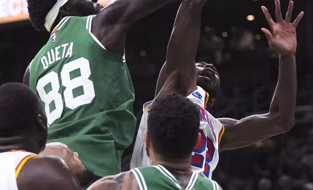 Boston Celtics center Neemias Queta (88) battles for a rebound against Golden State Warriors forward Andrew Wiggins (22) during the first half of an NBA basketball game, Wednesday, Nov. 6, 2024, in Boston. (AP Photo/Charles Krupa)