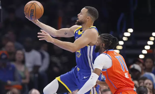 Golden State Warriors guard Stephen Curry, left, shoots in front of Oklahoma City Thunder guard Isaiah Joe (11) during the first half of an NBA basketball game, Sunday, Nov. 10, 2024, in Oklahoma City. (AP Photo/Nate Billings)