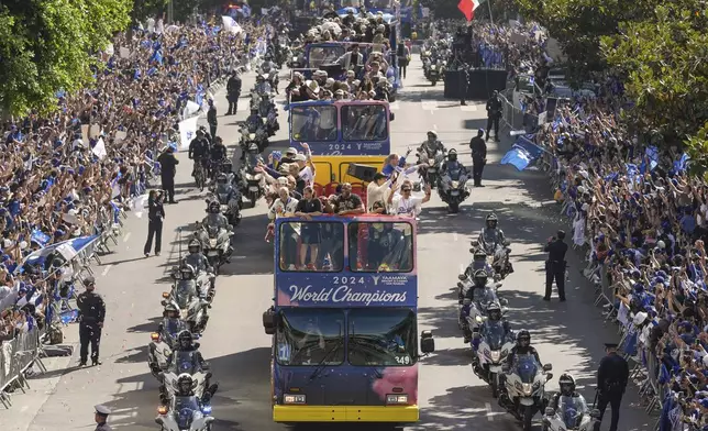 Los Angeles Dodgers players, coaches and ownership group are paraded on buses during the baseball team's World Series championship parade Friday, Nov. 1, 2024, in Los Angeles. (AP Photo/Damian Dovarganes)