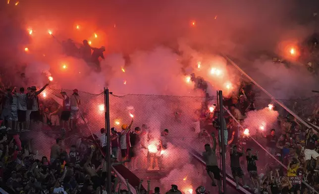 Fans of Argentina's Lanus launch fireworks before the start of a Copa Sudamericana semifinal second leg soccer match against Brazil's Cruzeiro at La Fortaleza Stadium in Buenos Aires, Argentina, Wednesday, Oct. 30, 2024. (AP Photo/Natacha Pisarenko)