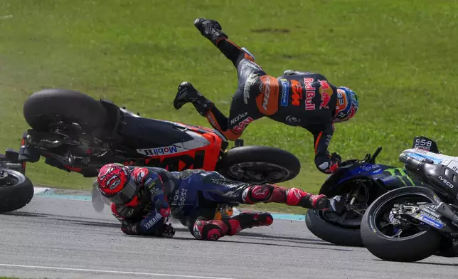 South African rider Brad Binder of Red Bull KTM Factory Racing, top, leaps in the air after crashing with French rider Fabio Quartararo of Monster Energy Yamaha during the start of the MotoGP race in Sepang, outskirts of Kuala Lumpur, Sunday, Nov. 3, 2024. (AP Photo/Vincent Thian)