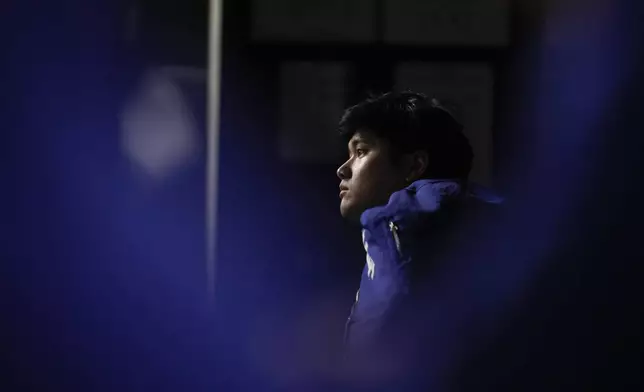 Los Angeles Dodgers' Shohei Ohtani watches in the dugout during the first inning in Game 5 of the baseball World Series against the New York Yankees, Wednesday, Oct. 30, 2024, in New York. (AP Photo/Ashley Landis)