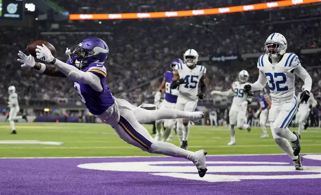 Minnesota Vikings wide receiver Jordan Addison (3) catches a 4-yard touchdown pass ahead of Indianapolis Colts safety Julian Blackmon (32) during the second half of an NFL football game, Sunday, Nov. 3, 2024, in Minneapolis. (AP Photo/Abbie Parr)