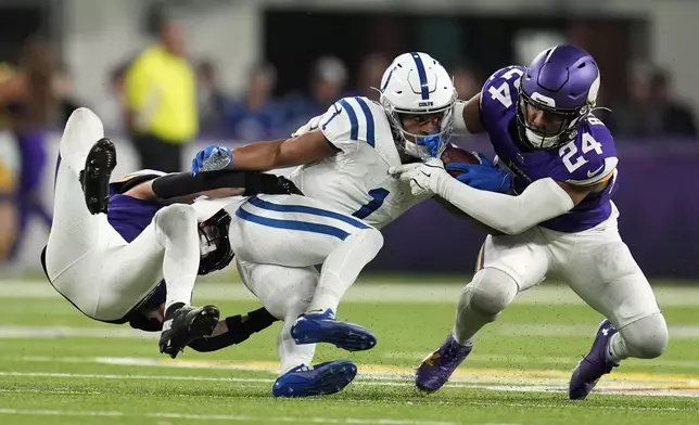 Indianapolis Colts wide receiver Josh Downs (1) is tackled by Minnesota Vikings cornerback Byron Murphy Jr., left, and safety Camryn Bynum (24) during the second half of an NFL football game, Sunday, Nov. 3, 2024, in Minneapolis. (AP Photo/Abbie Parr)