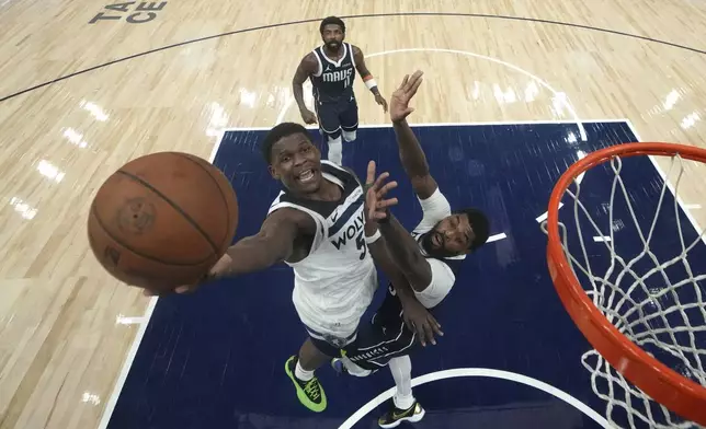 Minnesota Timberwolves guard Anthony Edwards, left, goes up for a shot as Dallas Mavericks forward Naji Marshall defends during the second half of an NBA basketball game, Tuesday, Oct. 29, 2024, in Minneapolis. (AP Photo/Abbie Parr)