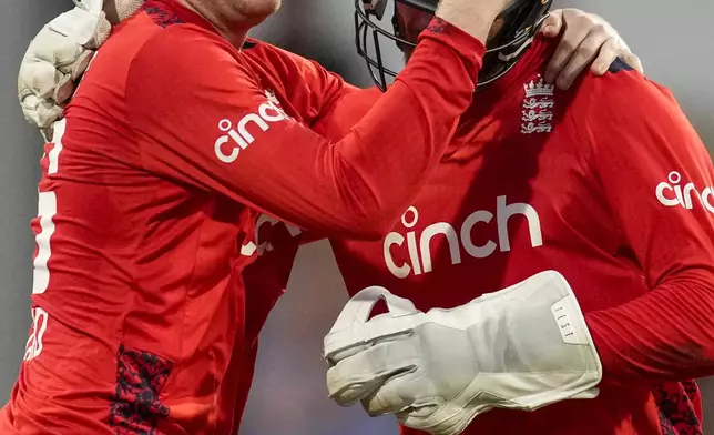 England's Dan Mousley, left, celebrates wicket keeper Phil Salt taking the wicket of West Indies' captain Rovman Powell during the second T20 cricket match at Kensington Oval in Bridgetown, Barbados, Sunday, Nov. 10, 2024. (AP Photo/Ricardo Mazalan)