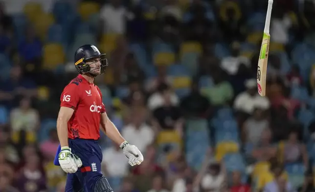 England's captain Jos Buttler throws his bat into the air as he walks off the field, caught by West Indies' captain Rovman Powell for 83 runs, during the second T20 cricket match at Kensington Oval in Bridgetown, Barbados, Sunday, Nov. 10, 2024. (AP Photo/Ricardo Mazalan)