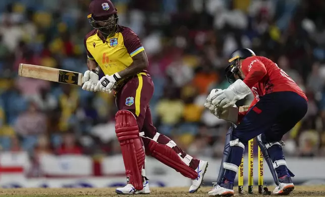 West Indies' Terrance Hinds plays a shot fro four runs as England's Phil Salt keeps wicket during the second T20 cricket match at Kensington Oval in Bridgetown, Barbados, Sunday, Nov. 10, 2024. (AP Photo/Ricardo Mazalan)