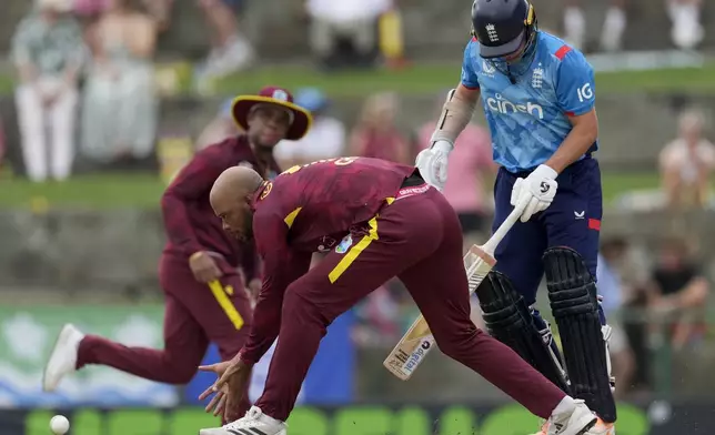 West Indies' Roston Chase fields next to England's Sam Curran during the first ODI cricket match at Sir Vivian Richards Ground in North Sound, Antigua and Barbuda, Thursday, Oct. 31, 2024. (AP Photo/Ricardo Mazalan)