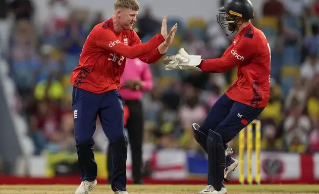 England's Dan Mousley, left, celebrates wicket keeper Phil Salt taking the wicket of West Indies' captain Rovman Powell during the second T20 cricket match at Kensington Oval in Bridgetown, Barbados, Sunday, Nov. 10, 2024. (AP Photo/Ricardo Mazalan)