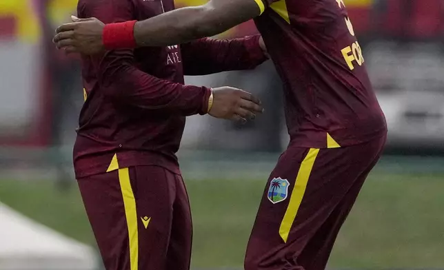 West Indies' Shimron Hetmyer, left, celebrates with Matthew Forde talking the catch to dismiss England's Sam Curran during the first ODI cricket match at Sir Vivian Richards Ground in North Sound, Antigua and Barbuda, Thursday, Oct. 31, 2024. (AP Photo/Ricardo Mazalan)